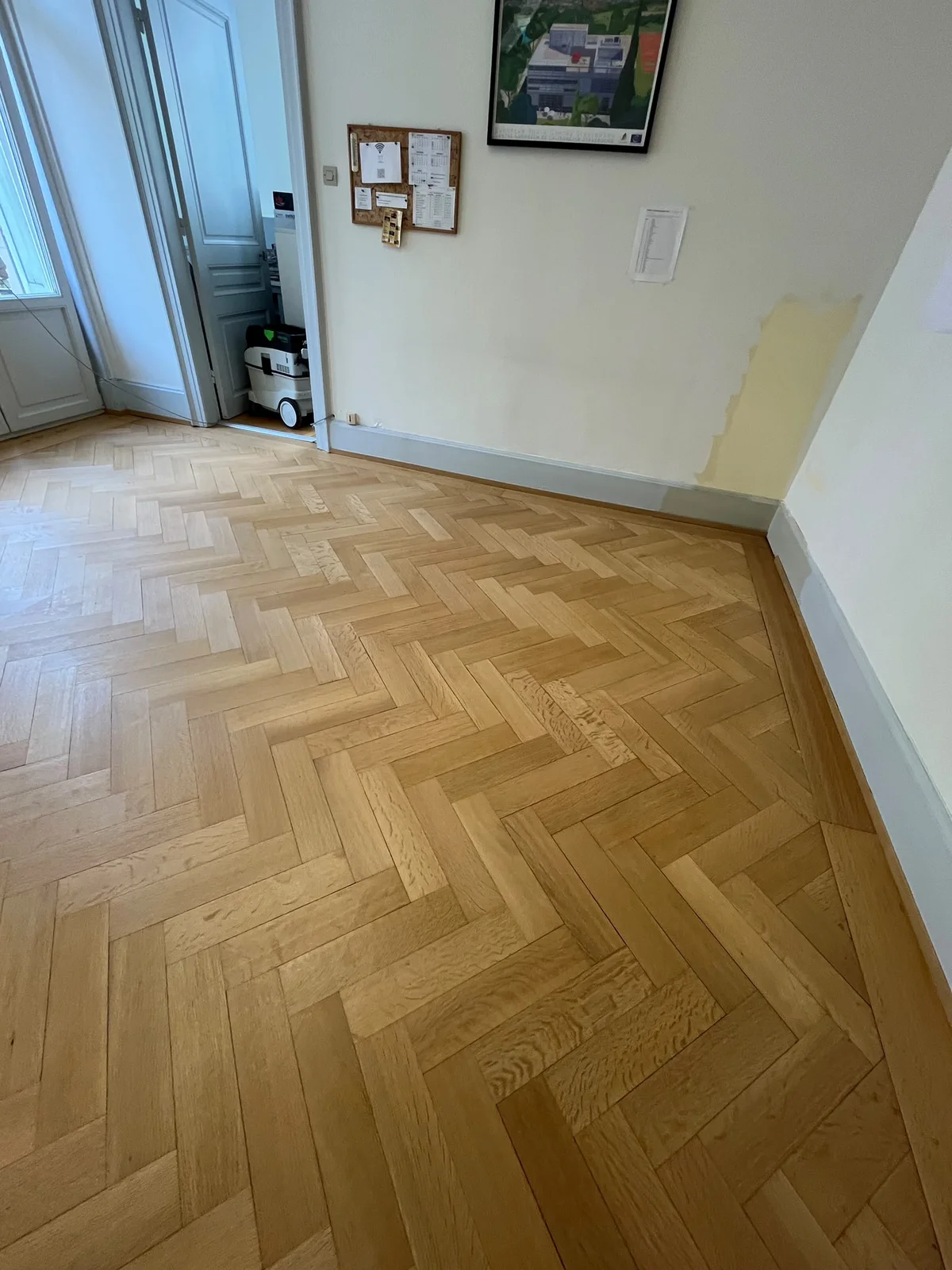 Parquet à bâtons rompus d'une pièce après la rénovation, bois clair et uniforme