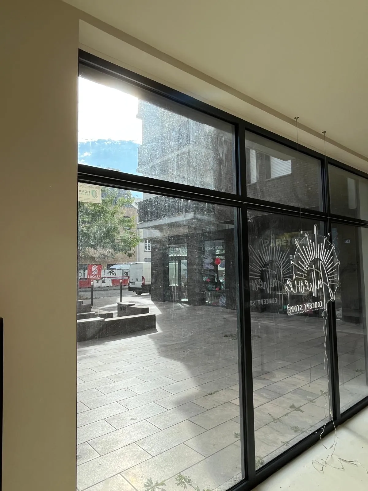 Grande baie vitrée d'une boutique vue de l'intérieur pendant le nettoyage